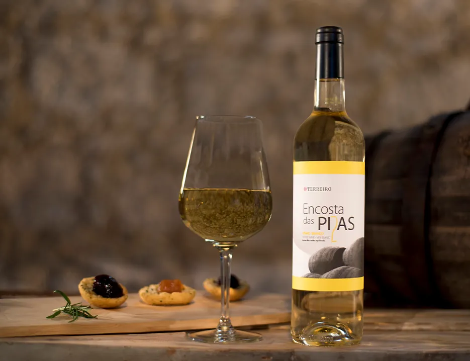 Garrafa e copo de vinho branco Encosta das Pias com petiscos