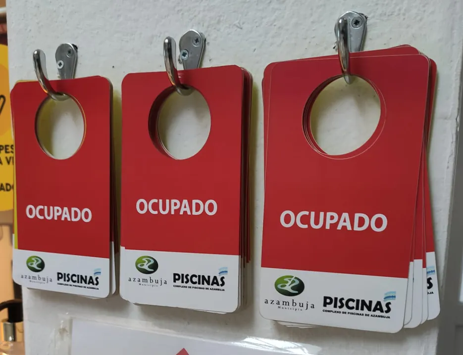 Placas de porta OCUPADO das Piscinas Municipais de Azambuja penduradas em ganchos